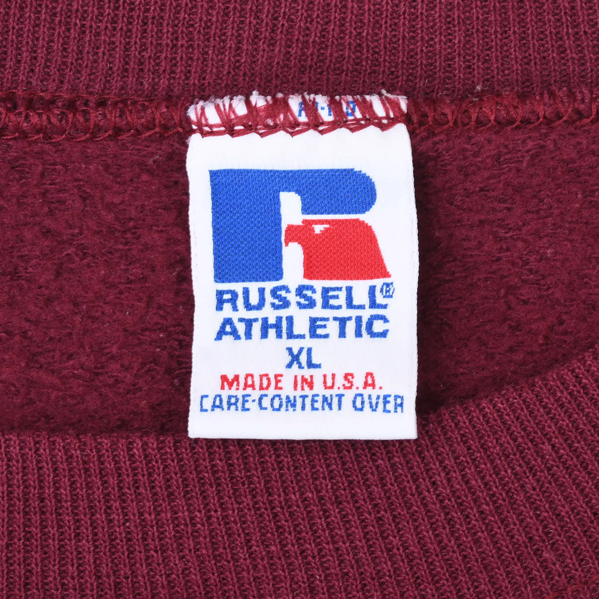 Close-up of Russell Athletic neck label marked XL and Made in U.S.A. inside burgundy sweatshirt