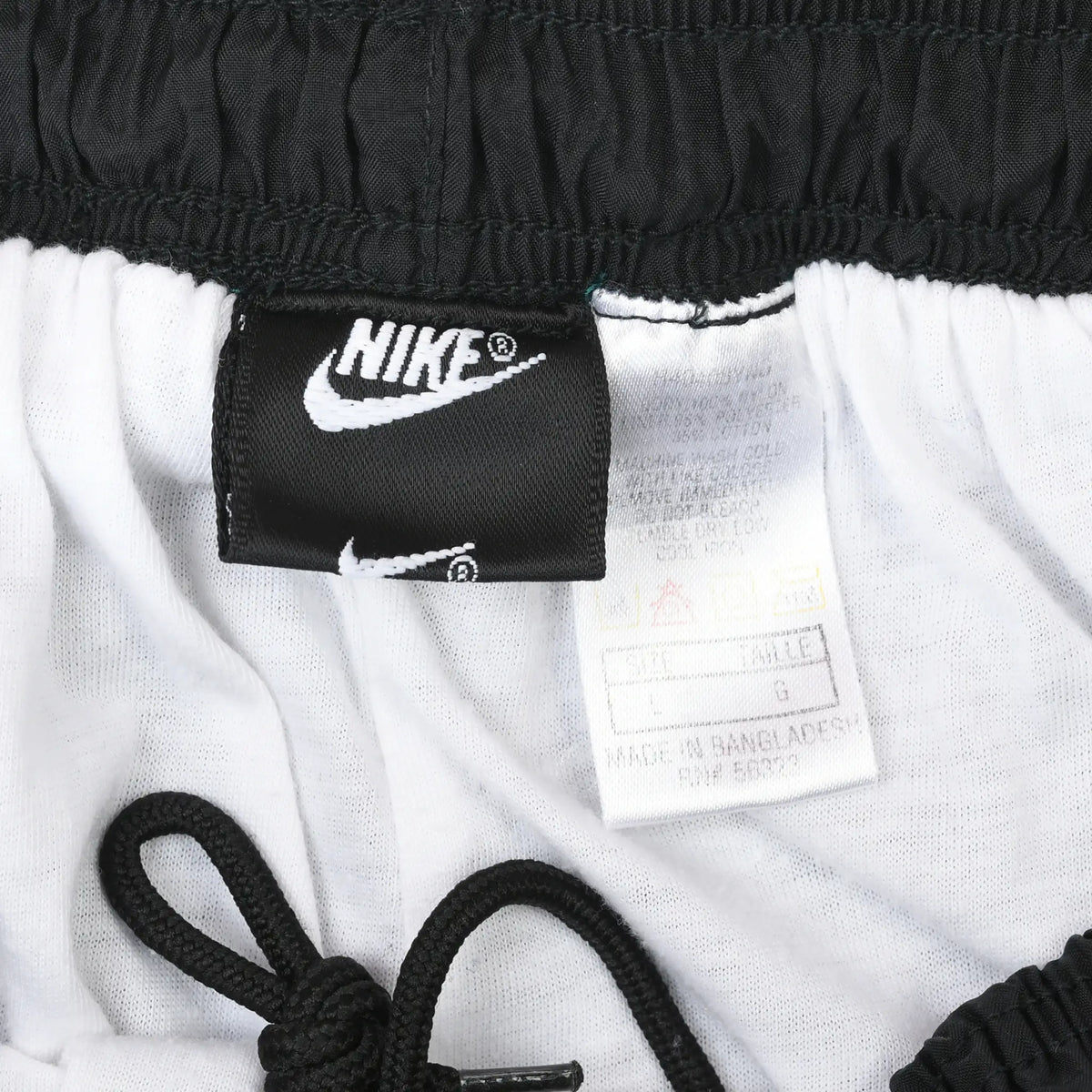 Interior waistband detail with Nike Swoosh label, care tag, white lining, and black drawcord