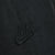 Close-up of tonal black Nike Swoosh embroidery on the track pants