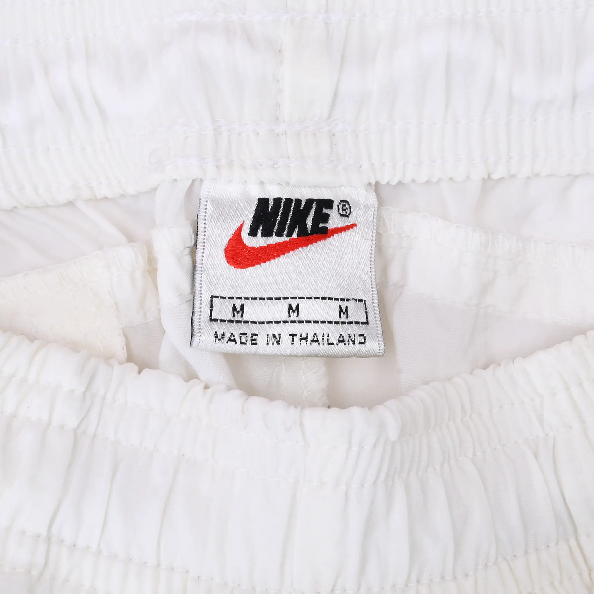 Nike waistband label with red Swoosh, size M, and Made in Thailand text
