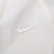 Close-up of tonal white Nike Swoosh embroidery on white fabric