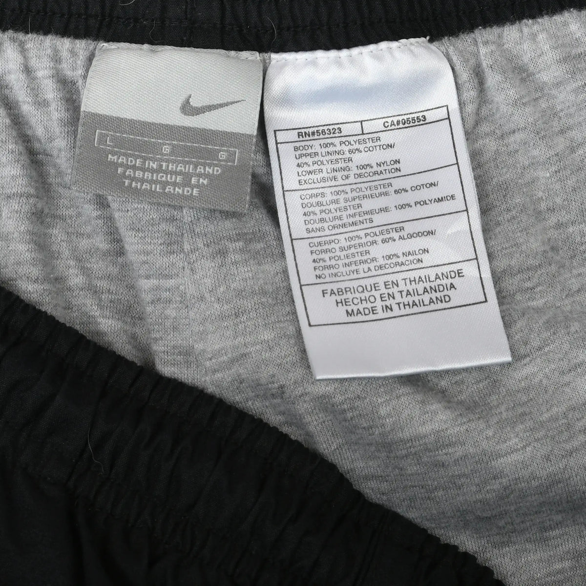 Nike interior care and manufacturing labels at the waistband of black track pants
