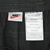 Nike brand and nylon care labels inside black track pants