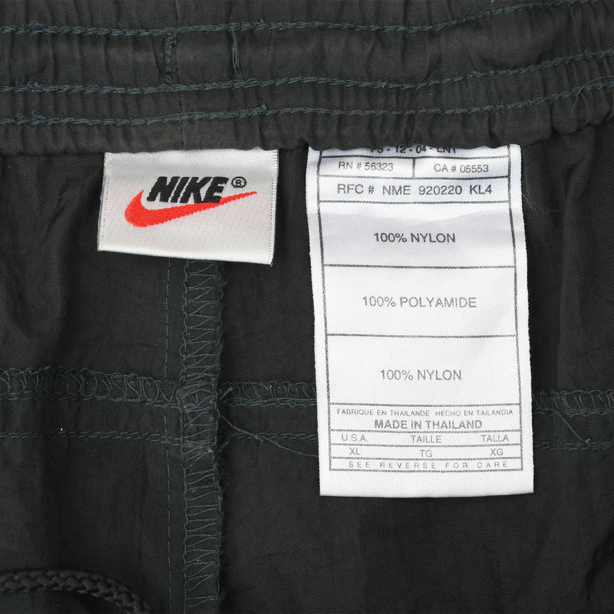 Nike brand and nylon care labels inside black track pants