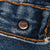 Close-up of metal waistband button stamped 511 inside Levi's blue jeans