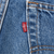 Close-up of red Levi's tab beside the back pocket seam on blue denim