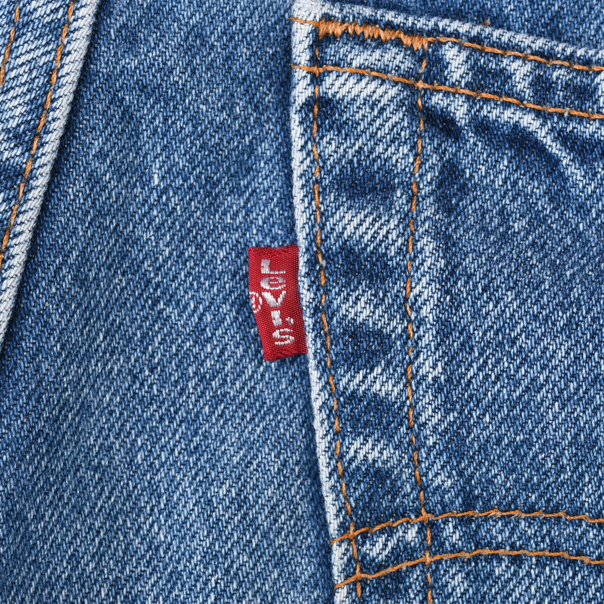 Close-up of red Levi's tab beside the back pocket seam on blue denim