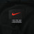 Nike neck label with red Swoosh and XXL size marking on black mesh lining