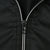 Close-up of black half-zip closure with white zipper teeth on Nike windbreaker
