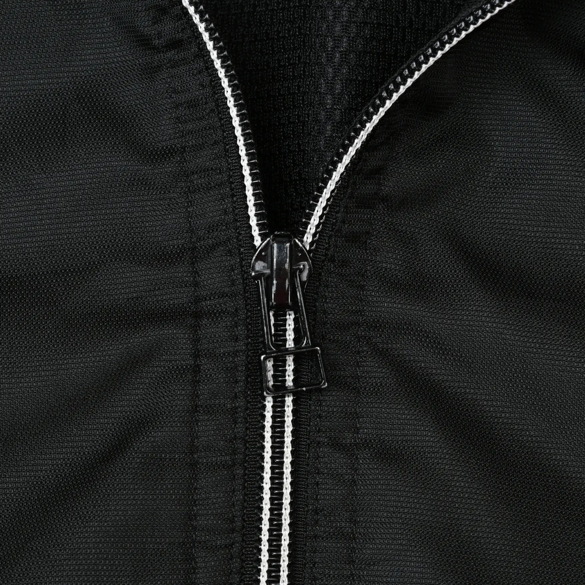Close-up of black half-zip closure with white zipper teeth on Nike windbreaker