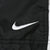 Close-up of white Nike Swoosh embroidery on black windbreaker fabric
