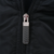 Close-up of Nike Swoosh zipper pull on the black jacket