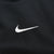 Close-up of small white Nike Swoosh embroidery on black fabric
