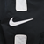 Close-up of large white Nike Swoosh and white panel details on black sleeve