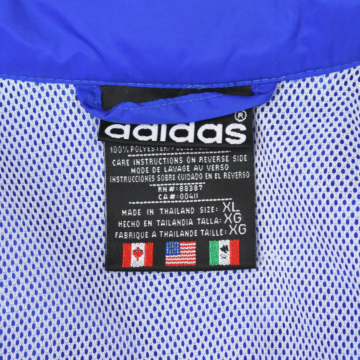 Close-up of adidas XL neck label against white mesh lining inside the blue windbreaker