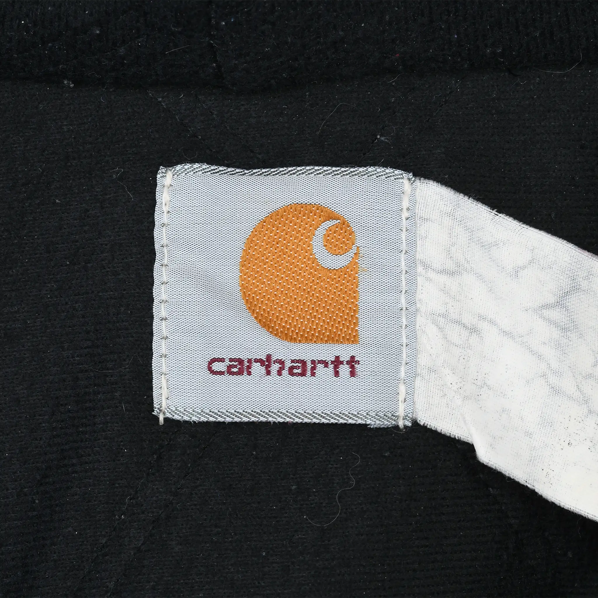 Close-up of interior Carhartt logo label against black jacket lining