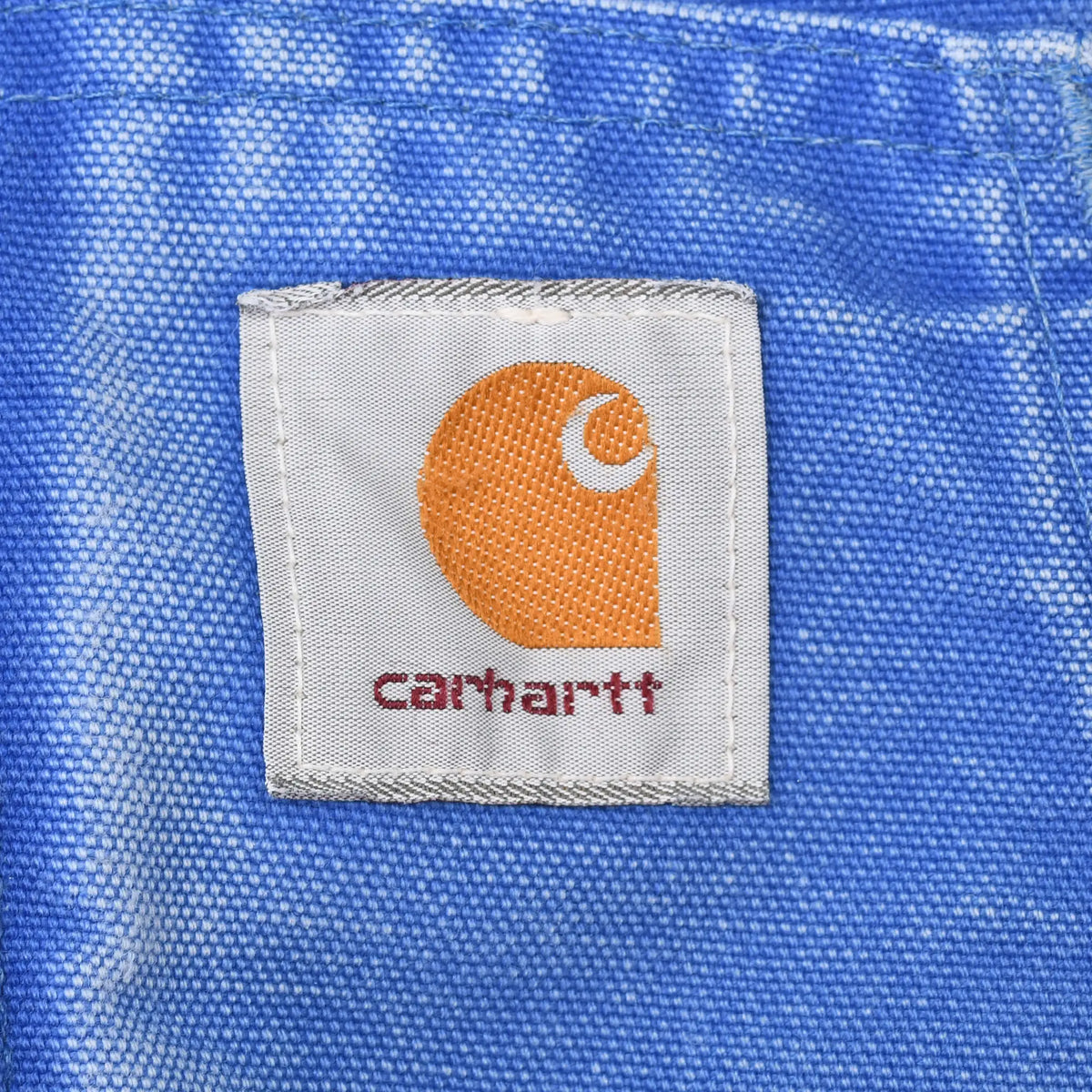 Close-up of Carhartt logo patch stitched to blue front pocket