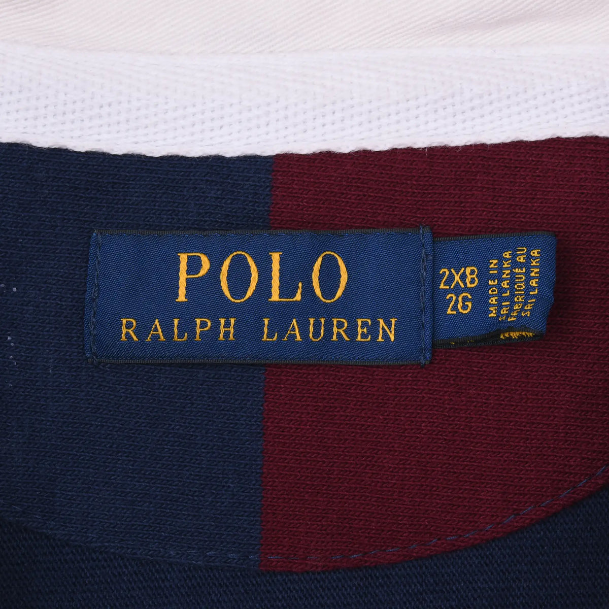 Close-up of Polo Ralph Lauren neck label marked 2XB 26 beneath the white collar