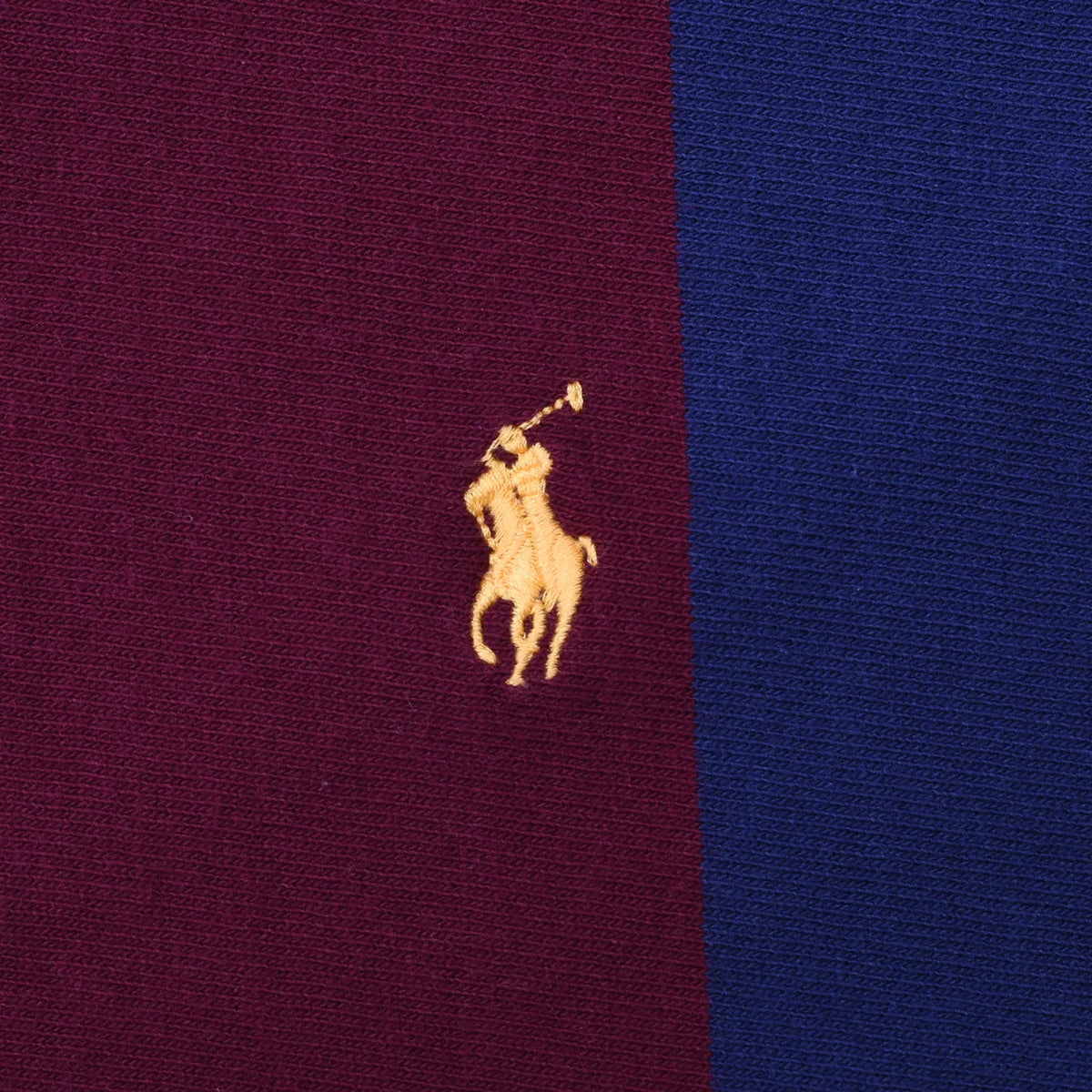 Close-up of yellow Polo pony embroidery on burgundy and navy striped fabric