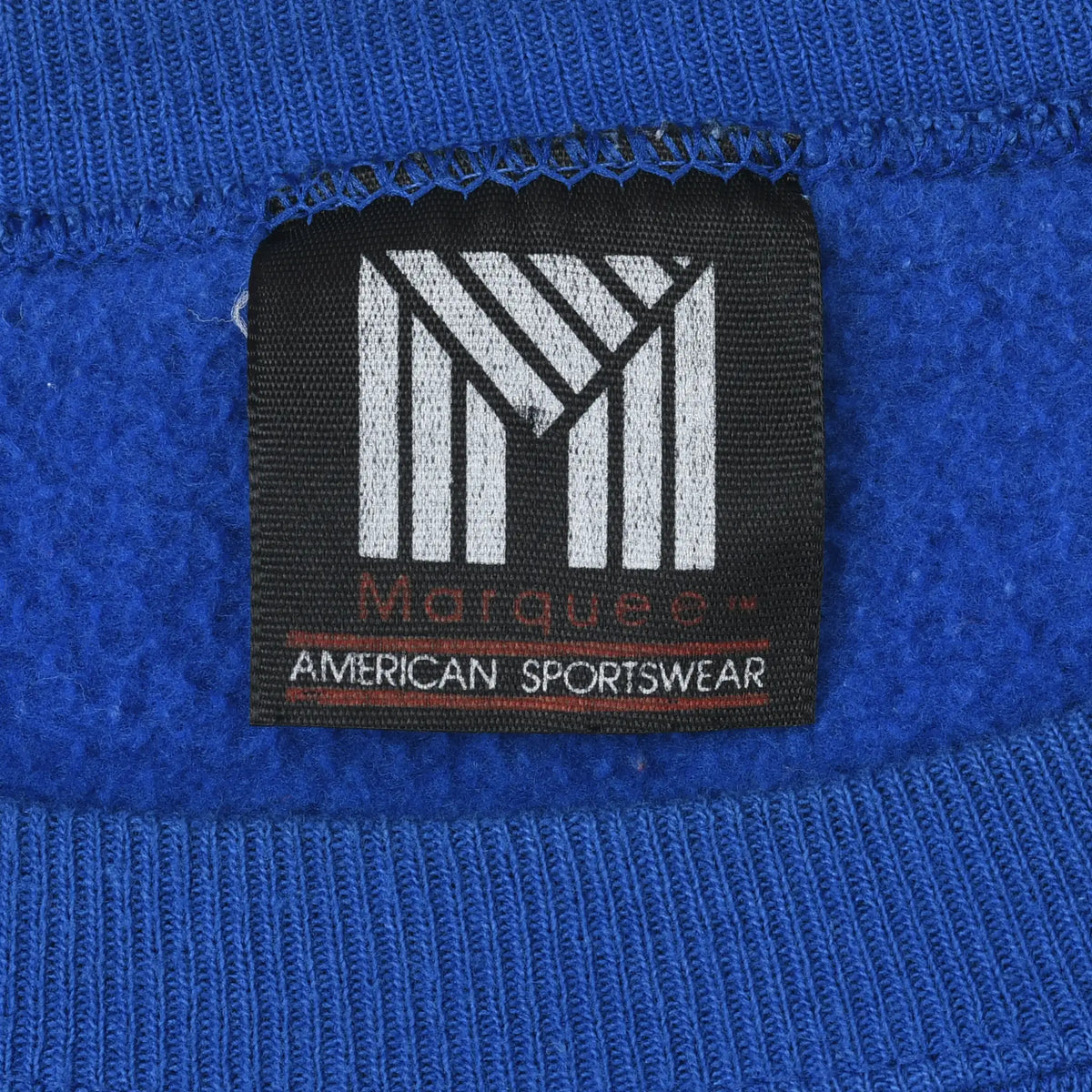 Close-up of Morning Sun American Sportswear neck label on blue sweatshirt