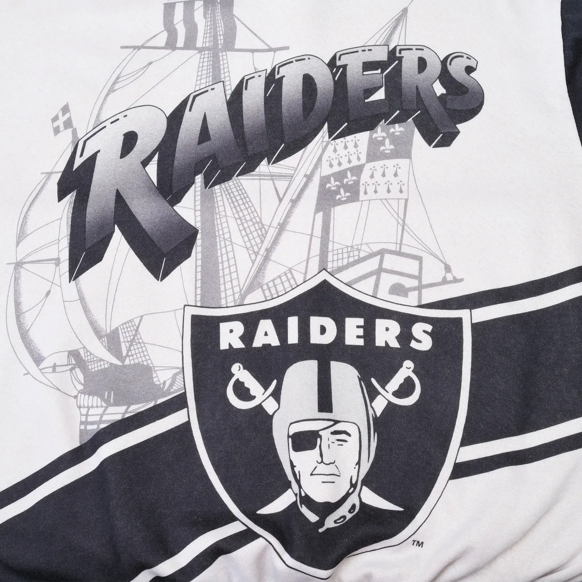 Close-up of back print with Raiders wordmark, sailing ship, shield, and black stripes