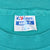 Close-up of Hanes Beefy-T neck label on teal T-shirt