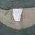 Close-up of blank white neck tag and dark green ribbed collar