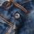 Close-up of Levi's jeans waistband button stamped 524 and orange stitching