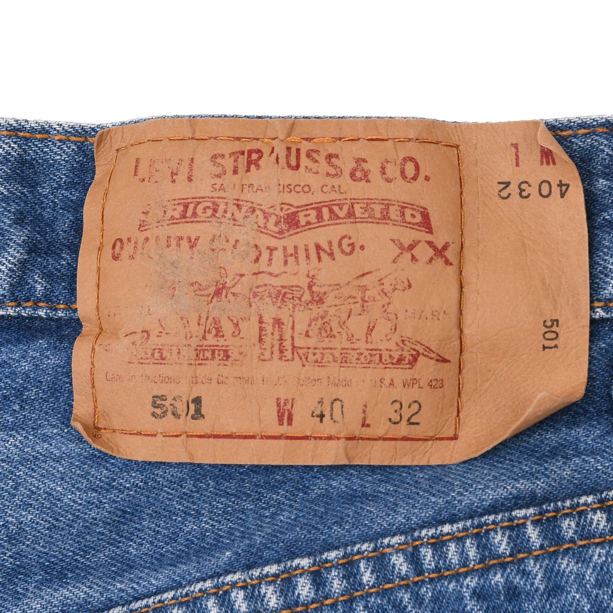 Close-up of tan Levi's 501 waistband patch marked W40 L32 on blue denim