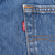 Close-up of red Levi's tab beside a back pocket seam on blue denim