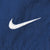 Close-up of white embroidered Nike Swoosh on navy blue fabric