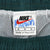 Nike size medium label inside green swim trunks above white mesh lining