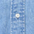 Close-up of white four-hole button and stitching on blue denim shirt placket