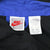 Close-up of Nike neck tag and care label inside the black and blue windbreaker