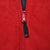 Close-up of red jacket zipper with black Nike Swoosh pull tab