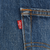 Close-up of red Levi's tab at the back pocket seam of blue jeans