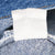 Reverse side of faded white interior label against blue denim seams