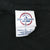 Close-up of Delta Pro Weight neck tag on black T-shirt