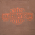 Close-up of orange Harley-Davidson Motor Cycles front print on brown fabric