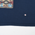 Close-up of navy T-shirt front near the hem, with Looney Tunes Blues print edge and a marked spot