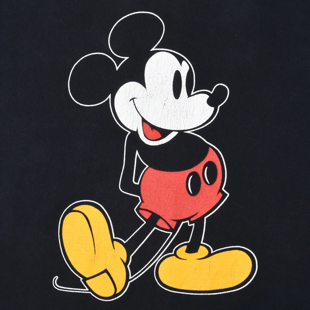 Close-up of Mickey Mouse print with red shorts and yellow shoes on black fabric