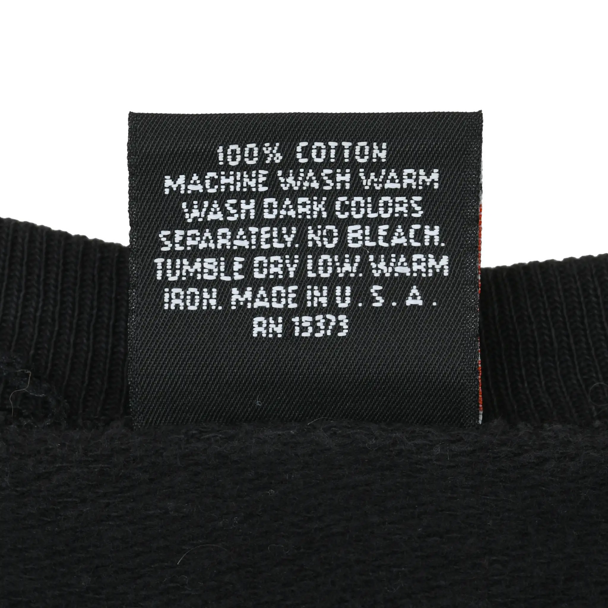 Close-up of 100% cotton care label with washing instructions and RN 13373