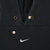 Close-up of hoodie neckline, metal eyelets, and white center Nike Swoosh with marked areas
