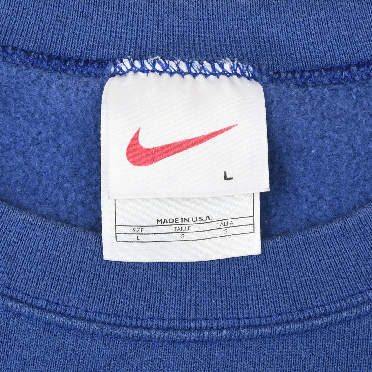 Nike neck tag with red Swoosh, size L, and Made in U.S.A. text inside blue sweatshirt