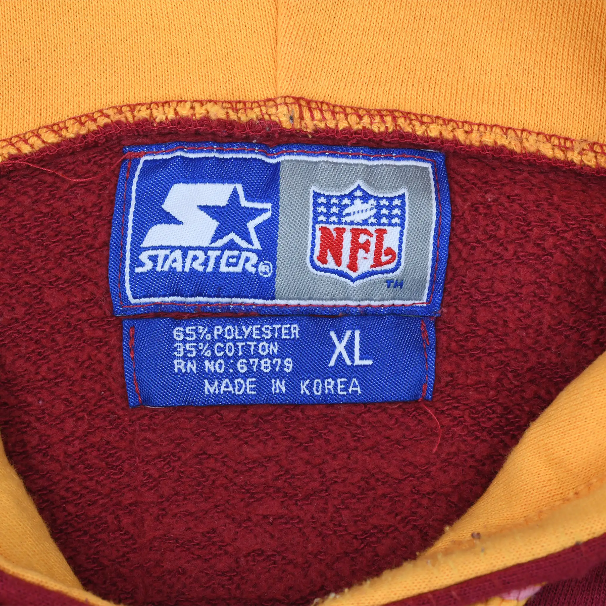 Close-up of Starter NFL neck label marked XL inside the burgundy and gold hoodie