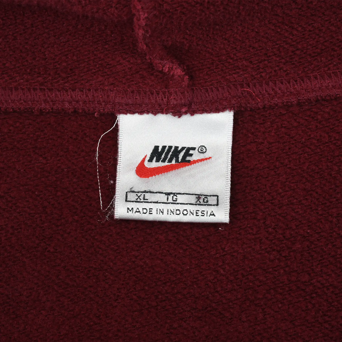 Close-up of Nike neck label marked XL on burgundy hoodie