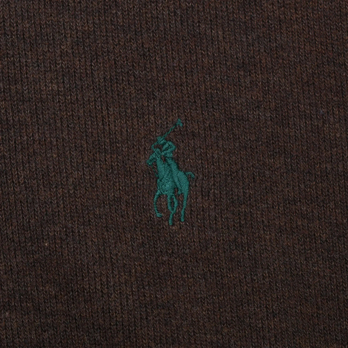 Close-up of green Polo pony embroidery on brown sweater fabric