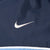 Close-up of white Nike Swoosh embroidery on navy fabric