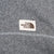The North Face logo patch and contrast stitching on grey jacket chest