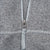 Close-up of quarter-zip pull and contrast stitching on grey jacket